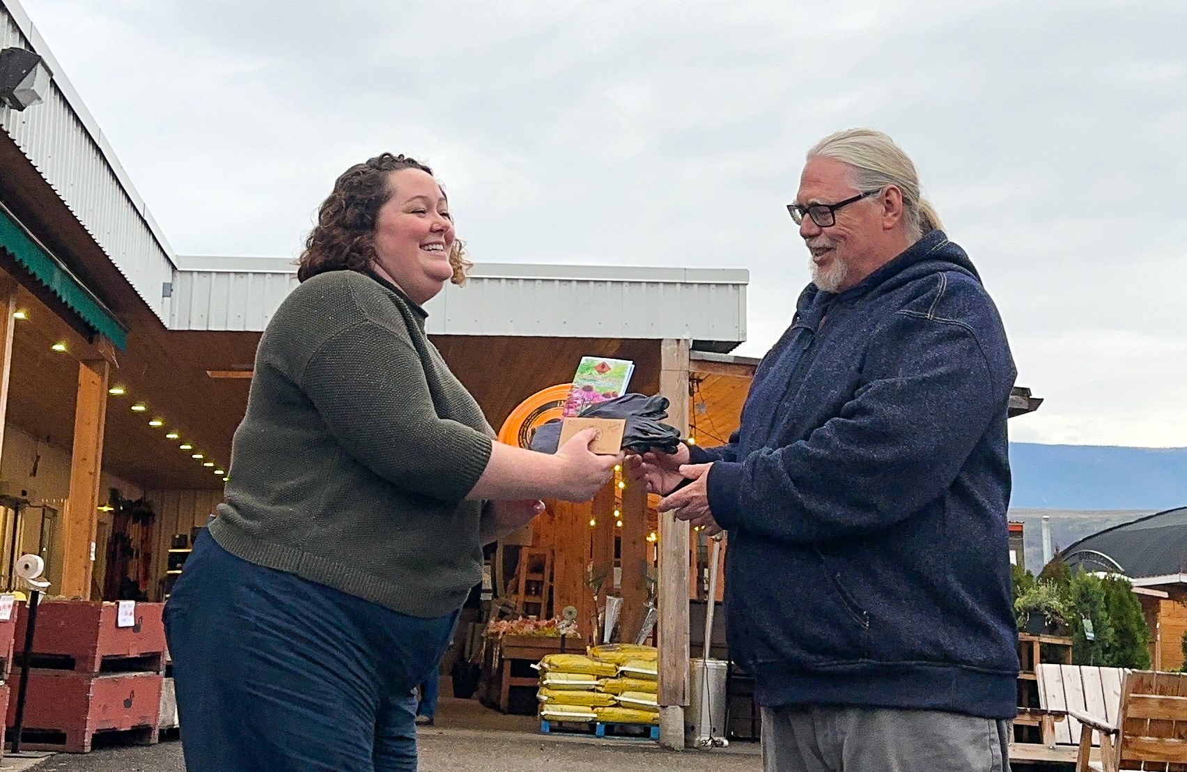 Ken De Groot receives a $500 WaterWise yard upgrade certificate for Swan Lake Market & Garden from OBWB Communications Coordinator Amanda Burnett.